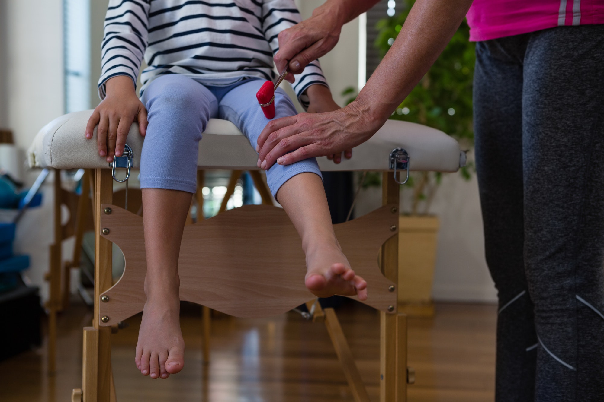 Doctor examining reflexes of patient knee
